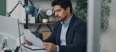 Latin American prior authorization specialist reviewing paperwork